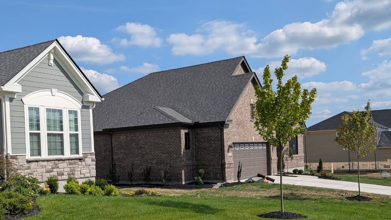 Healthy, evenly green front lawn in front of a newly built home on a sunny day.